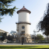 Historic Fresno water tower with red roof, clock face, and urban park setting
