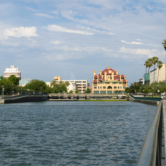 Stockton waterfront with ornate red‑yellow landmark, palm trees, and canal walkway
